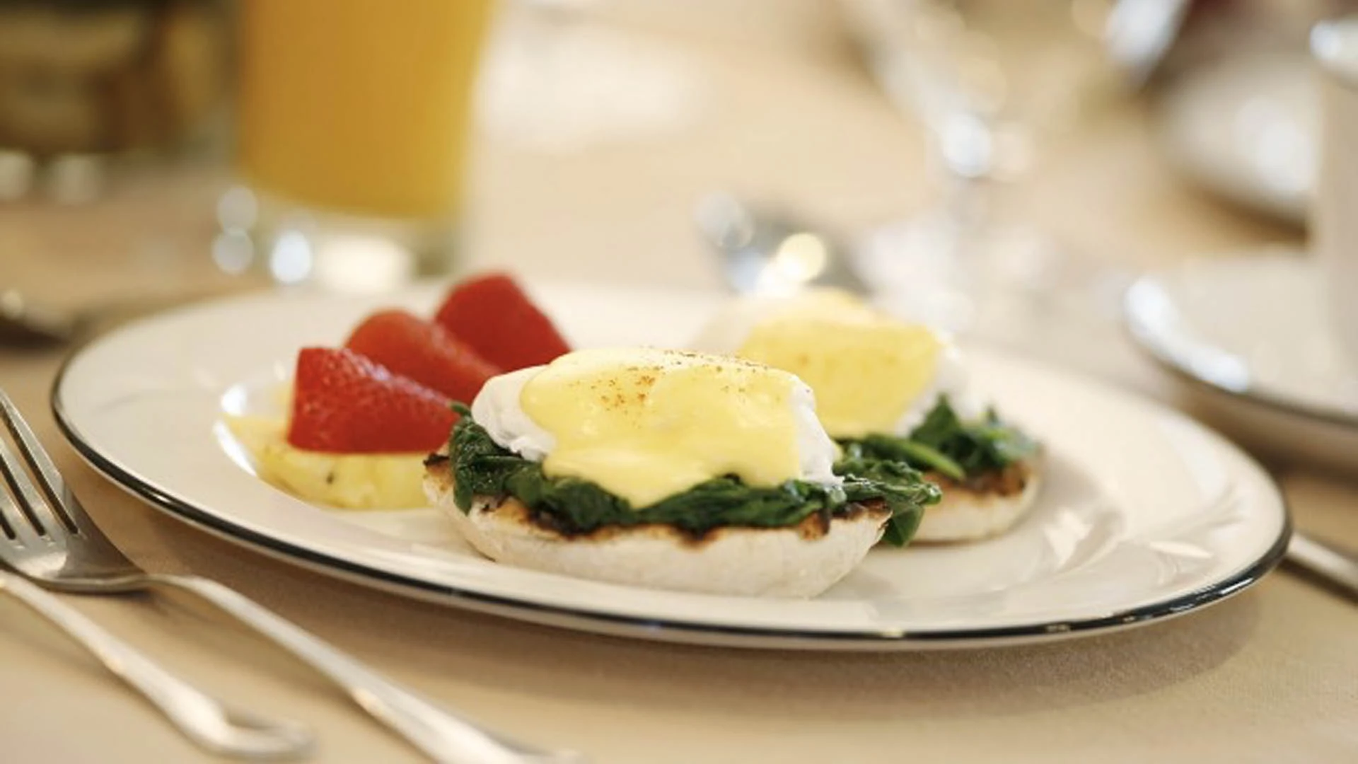 Eggs Benedict on a plate with fruit. Healthy meals for seniors