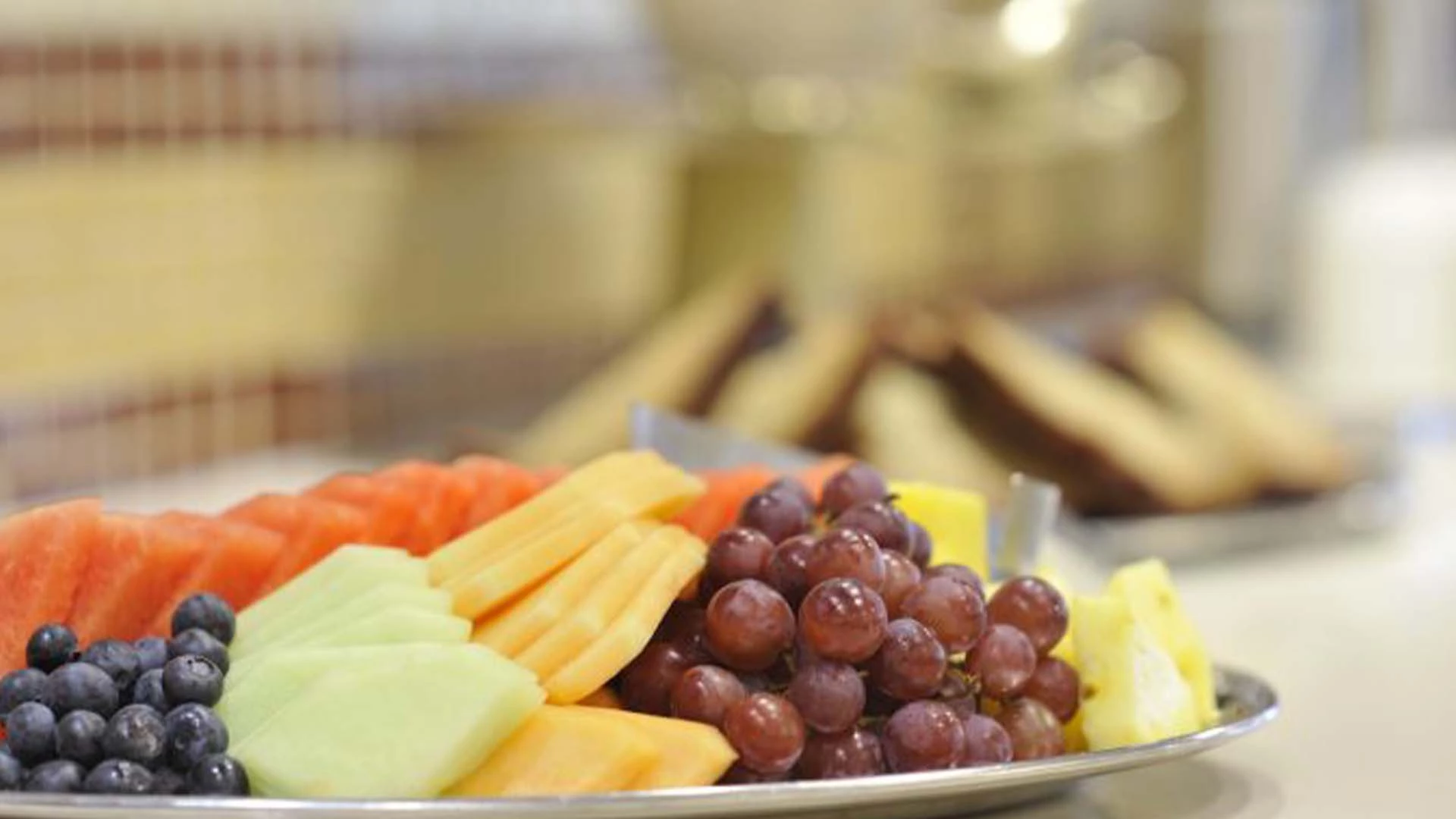 A fruit tray with melons, grapes, berries, and pineapple, Soft snacks for elderly