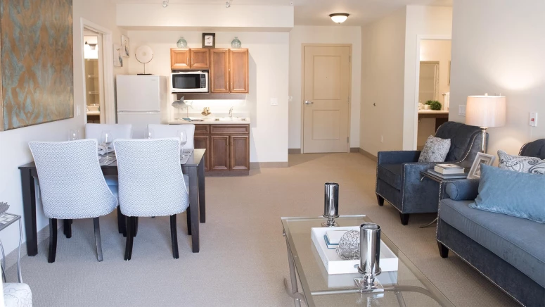 A kitchenette and living room in a Sage Hill suite