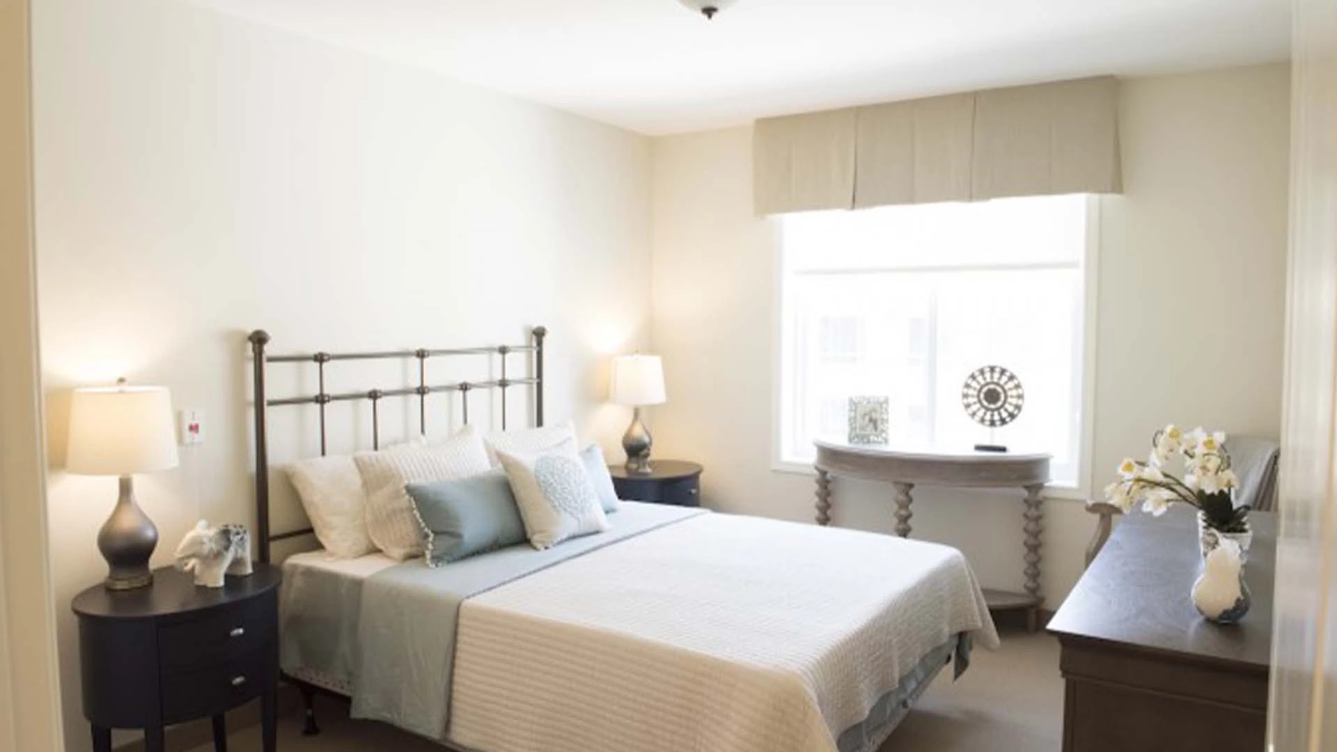 A bed, dresser, and side tables in a Sage Hill senior apartments