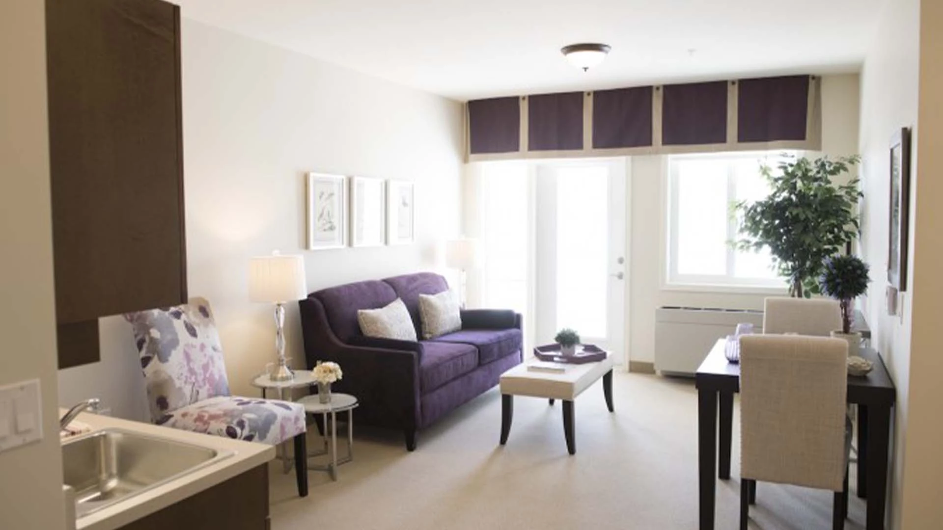 A living room with a purple couch in a Sage Hill senior apartment.