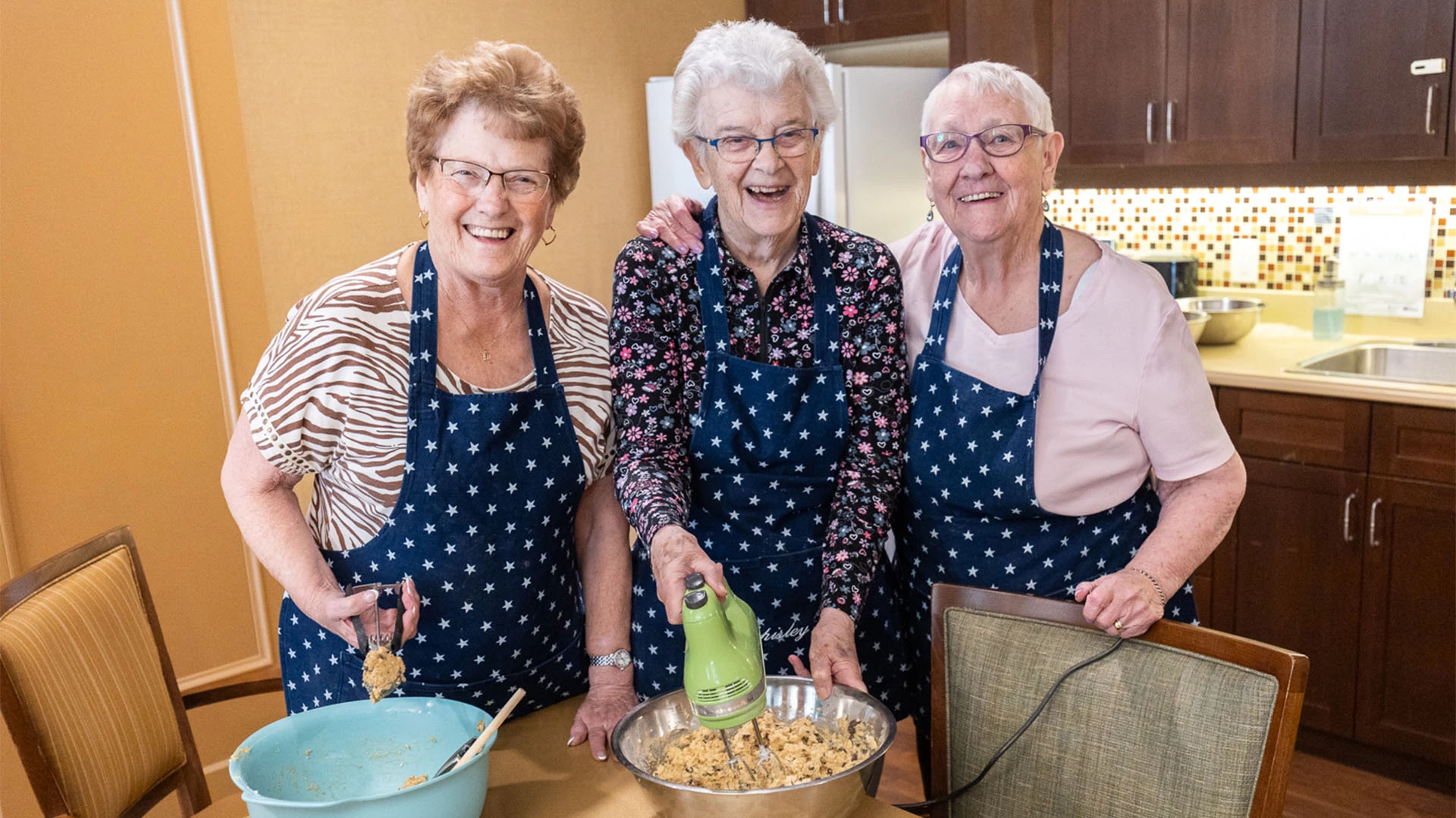 Three female seniors baking cookies